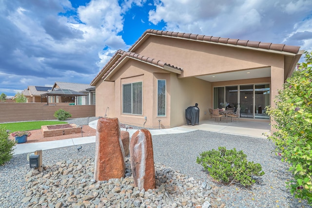 2952 Kings Canyon Loop NE, Rio Rancho, NM 87144 - back of house featuring a patio, stucco siding, a tile roof, and a vegetable garden