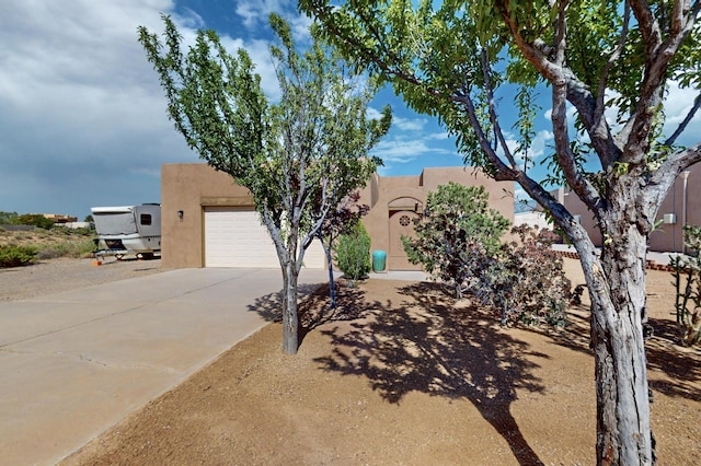 2504 Campeche Rd NE, Rio Rancho, NM 87144 - pueblo-style home featuring stucco siding, concrete driveway, and a garage
