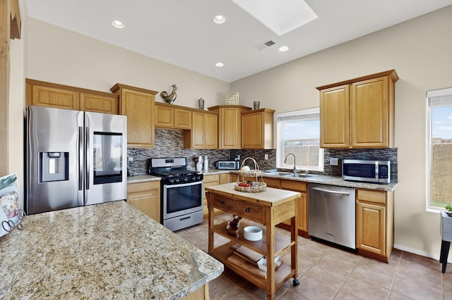 2504 Campeche Rd NE, Rio Rancho, NM 87144 - kitchen featuring appliances with stainless steel finishes, a skylight, decorative backsplash, light tile patterned flooring, and recessed lighting