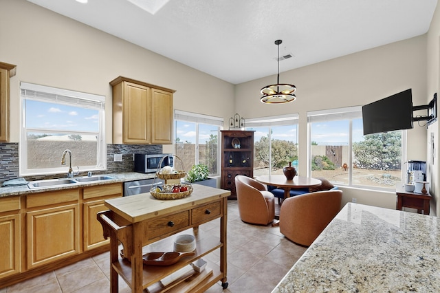 2504 Campeche Rd NE, Rio Rancho, NM 87144 - kitchen with stainless steel appliances, light tile patterned flooring, decorative backsplash, pendant lighting, and light stone counters