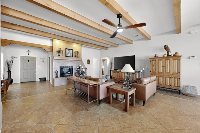 2504 Campeche Rd NE, Rio Rancho, NM 87144 - living area with beamed ceiling, a fireplace with raised hearth, ceiling fan, light tile patterned floors, and arched walkways
