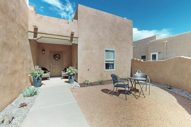 2504 Campeche Rd NE, Rio Rancho, NM 87144 - view of exterior entry with stucco siding and a patio area