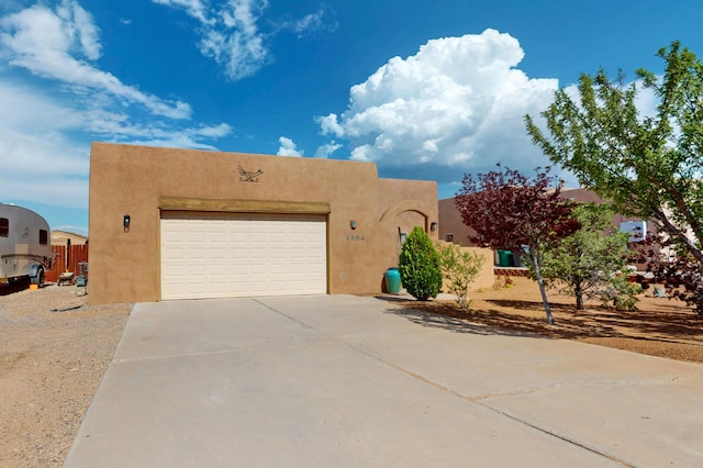 2504 Campeche Rd NE, Rio Rancho, NM 87144 - pueblo-style home with stucco siding, driveway, and a garage