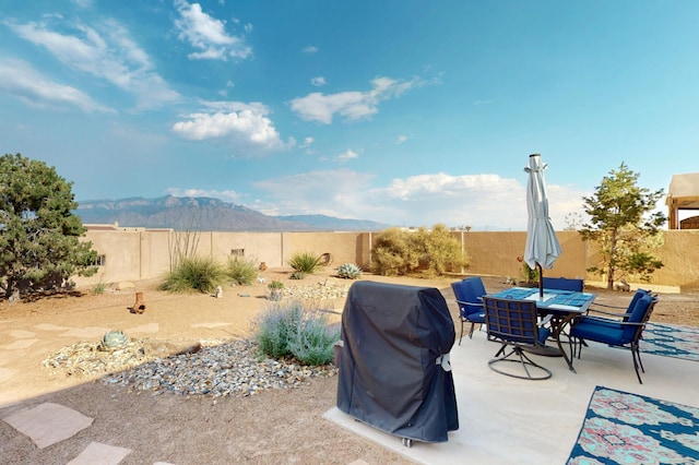 2504 Campeche Rd NE, Rio Rancho, NM 87144 - fenced backyard featuring area for grilling, a mountain view, a patio, and outdoor dining space