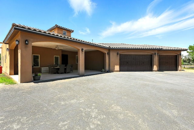 76 Otero Rd, Los Lunas, NM 87031 - mediterranean / spanish-style house with stucco siding, a tile roof, an attached garage, and asphalt driveway