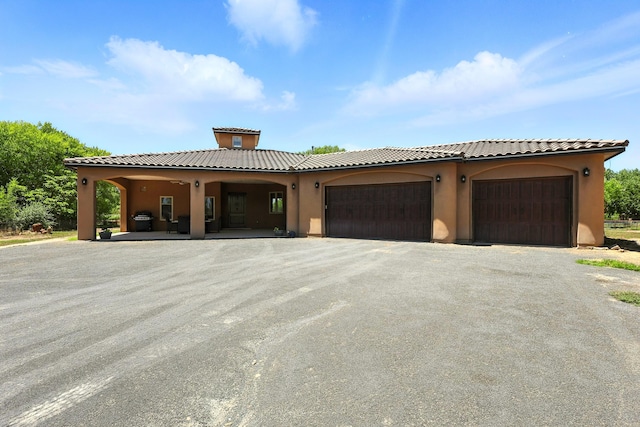 76 Otero Rd, Los Lunas, NM 87031 - view of front of property featuring stucco siding, asphalt driveway, a tile roof, and an attached garage