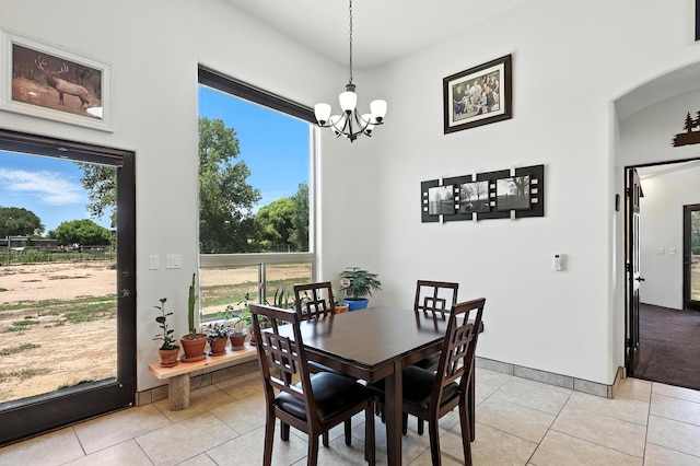 76 Otero Rd, Los Lunas, NM 87031 - dining room with light tile patterned floors, a chandelier, and arched walkways