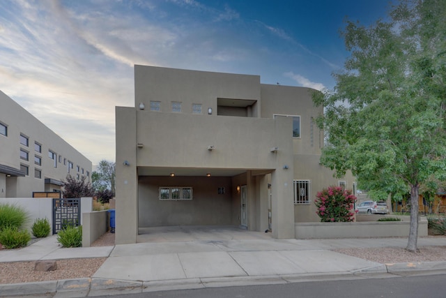 315 11th St SW, Albuquerque, NM 87102 - view of front of home featuring stucco siding, driveway, and a gate