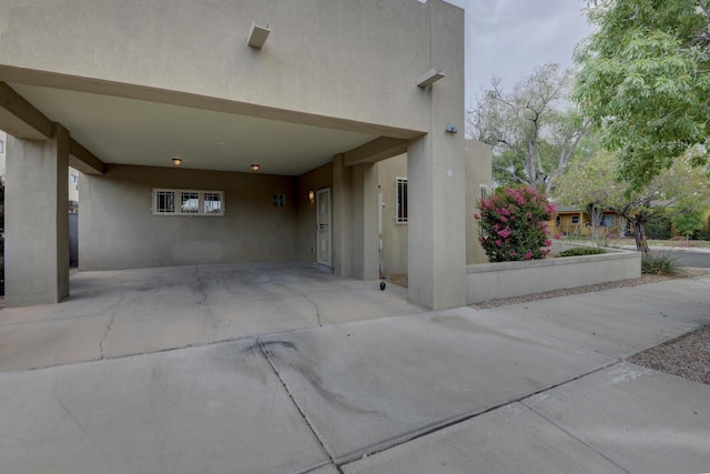 315 11th St SW, Albuquerque, NM 87102 - view of home's exterior with stucco siding, an attached carport, and driveway