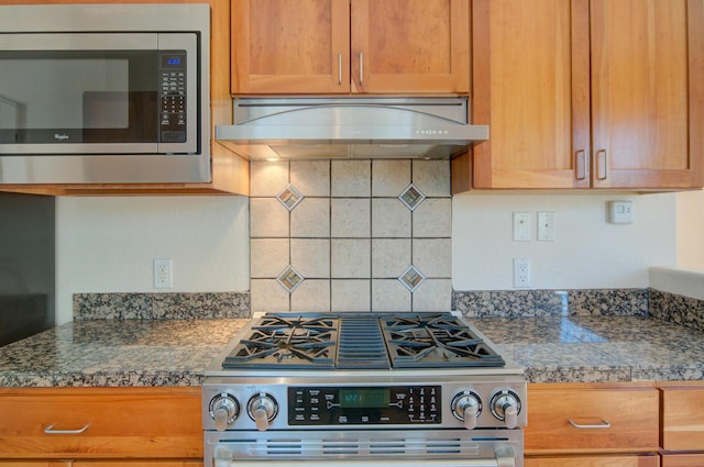 315 11th St SW, Albuquerque, NM 87102 - kitchen with stainless steel appliances, exhaust hood, tile countertops, tasteful backsplash, and brown cabinets