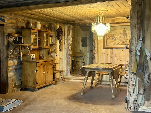 sitting room featuring wooden ceiling, wooden walls, finished concrete floors, and a chandelier