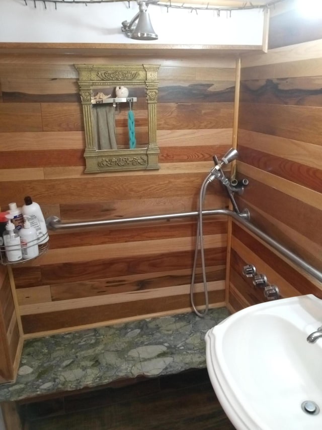 bathroom with a sink and wood walls