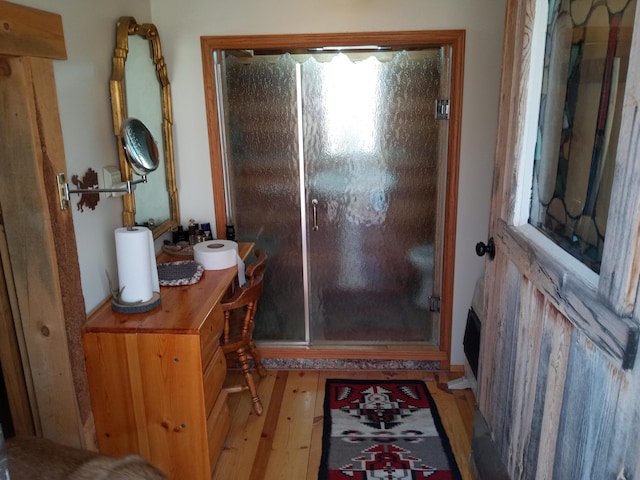 bathroom featuring a shower stall, vanity, and hardwood / wood-style flooring