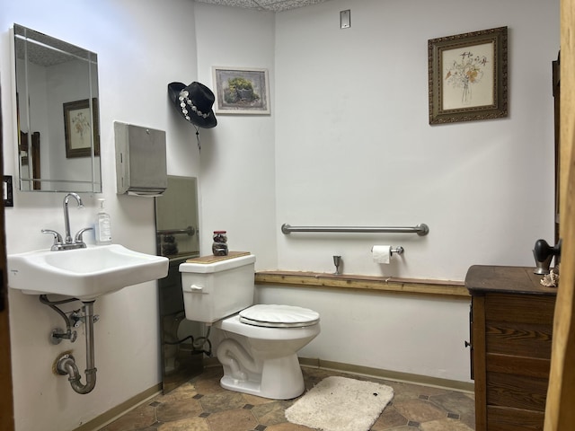 half bath featuring toilet and baseboards