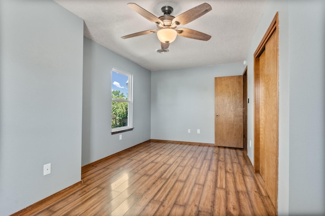 36 Palomas Rd, Los Lunas, NM 87031 - unfurnished bedroom featuring wood finished floors, a closet, a textured ceiling, and a ceiling fan