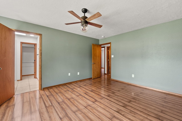 36 Palomas Rd, Los Lunas, NM 87031 - unfurnished bedroom featuring light wood finished floors, a textured ceiling, and a ceiling fan