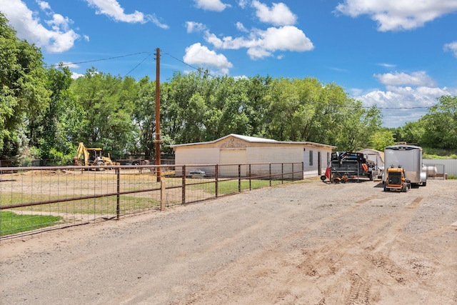 36 Palomas Rd, Los Lunas, NM 87031 - view of front of home with an outdoor structure, a playground, and view of wooded area