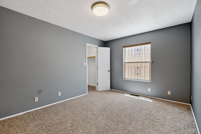 5415 Colleens Way NE, Albuquerque, NM 87111 - unfurnished bedroom with carpet, a textured ceiling, and a walk in closet