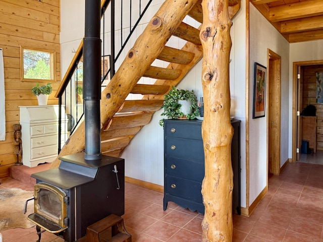 195 Ferguson Rd, Ramah, NM 87321 - stairs featuring a wood stove, tile patterned flooring, wooden walls, and beamed ceiling