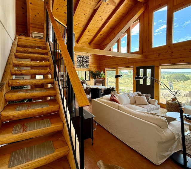 195 Ferguson Rd, Ramah, NM 87321 - living room featuring a wooden ceiling with exposed beams, high vaulted ceiling, wood walls, healthy amount of natural light, and stairway
