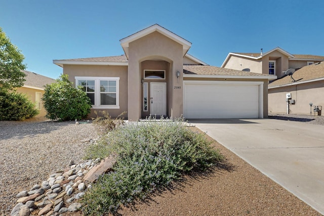 2048 N Ensenada Cir SE, Rio Rancho, NM 87124 - view of front of property featuring a garage, stucco siding, and concrete driveway
