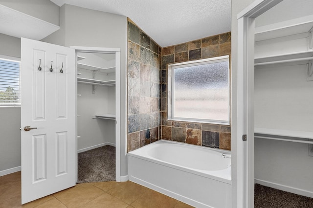 2048 N Ensenada Cir SE, Rio Rancho, NM 87124 - full bath featuring a spacious closet, a bath, plenty of natural light, tile patterned floors, and a textured ceiling
