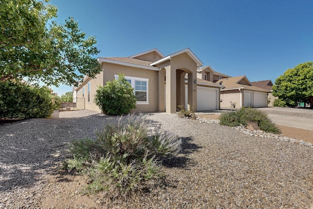 2048 N Ensenada Cir SE, Rio Rancho, NM 87124 - view of front of home with stucco siding, a garage, and driveway