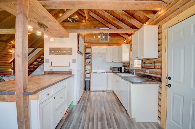 58 Quiet Valley Loop, Edgewood, NM 87015 - kitchen with stainless steel microwave, rustic walls, light wood-style flooring, white cabinetry, and dark countertops