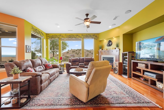 2308 Desert View Rd NE, Rio Rancho, NM 87144 - living area featuring a ceiling fan, wood finished floors, a glass covered fireplace, and recessed lighting