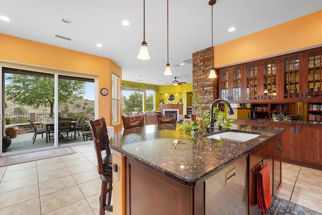 2308 Desert View Rd NE, Rio Rancho, NM 87144 - kitchen with a fireplace, light tile patterned floors, ceiling fan, a center island with sink, and recessed lighting