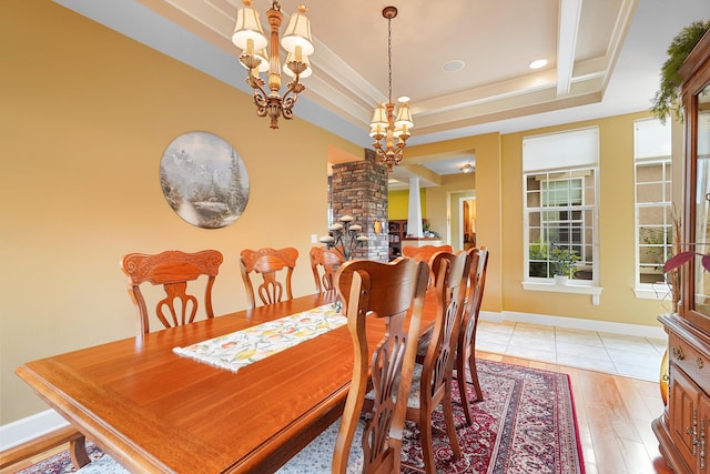 2308 Desert View Rd NE, Rio Rancho, NM 87144 - dining room featuring a raised ceiling, a chandelier, recessed lighting, light wood finished floors, and ornate columns