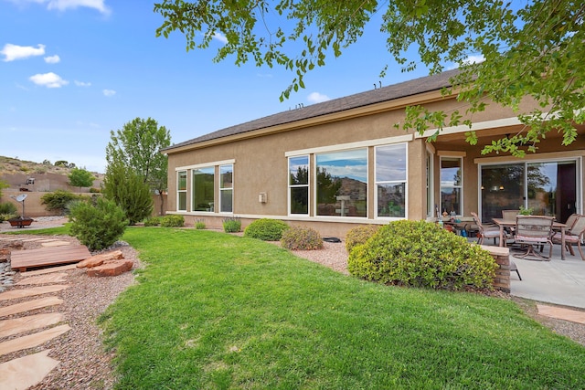 2308 Desert View Rd NE, Rio Rancho, NM 87144 - back of house featuring stucco siding, a yard, and a patio area