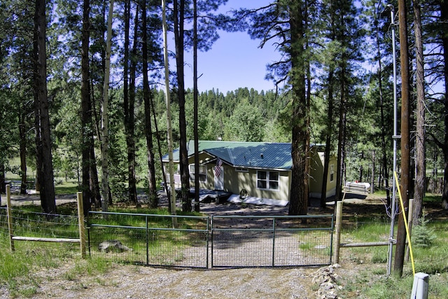 150 Ponderosa Way, Jemez Springs, NM 87025 - back of property featuring a gate, a view of trees, and a metal roof