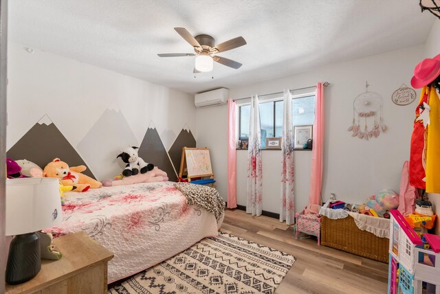 1257 Dinkle Rd, Stanley, NM 87056 - bedroom with a wall unit AC, wood finished floors, and a ceiling fan