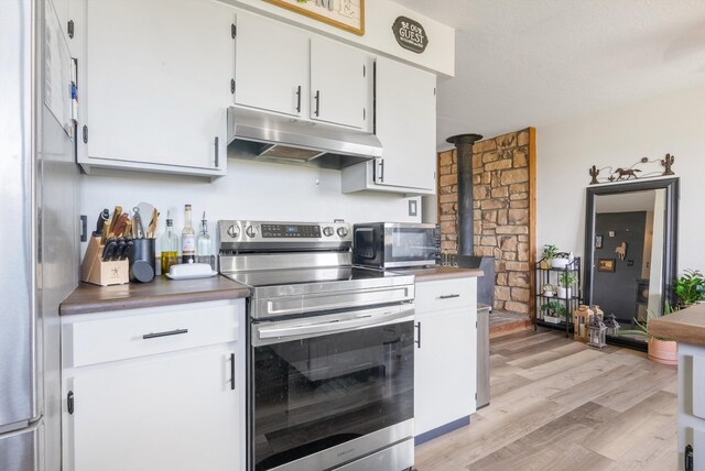 1257 Dinkle Rd, Stanley, NM 87056 - kitchen featuring stainless steel appliances, under cabinet range hood, light wood-style flooring, and white cabinetry