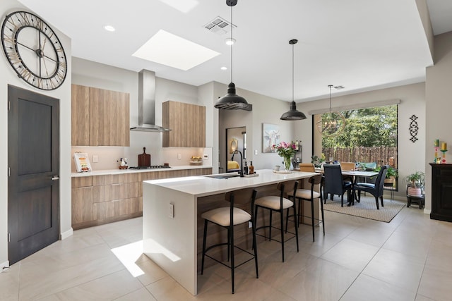 3204 Maxum Ln NW, Albuquerque, NM 87104 - kitchen with wall chimney exhaust hood, modern cabinets, light countertops, an island with sink, and recessed lighting