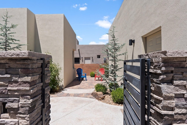 3204 Maxum Ln NW, Albuquerque, NM 87104 - view of home's exterior with stucco siding, a patio, and a gate