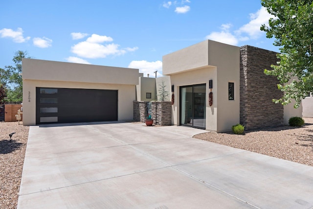3204 Maxum Ln NW, Albuquerque, NM 87104 - contemporary house featuring stucco siding, a garage, and stone siding