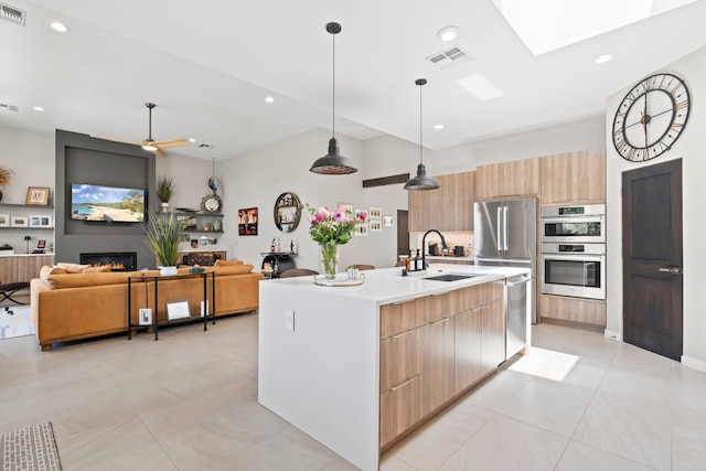 3204 Maxum Ln NW, Albuquerque, NM 87104 - kitchen featuring modern cabinets, stainless steel appliances, light countertops, open floor plan, and a skylight