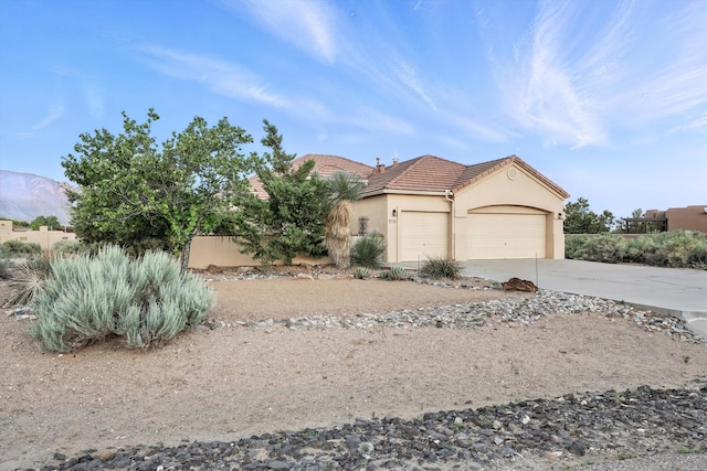 736 Gray Hawk Dr NE, Rio Rancho, NM 87144 - view of front of house featuring a tile roof, an attached garage, stucco siding, driveway, and a mountain view