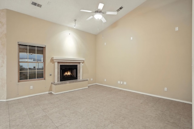 736 Gray Hawk Dr NE, Rio Rancho, NM 87144 - unfurnished living room featuring lofted ceiling, light tile patterned floors, a ceiling fan, and a warm lit fireplace