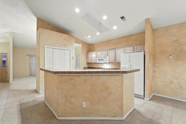 736 Gray Hawk Dr NE, Rio Rancho, NM 87144 - kitchen featuring white appliances, tile countertops, a skylight, light tile patterned floors, and vaulted ceiling