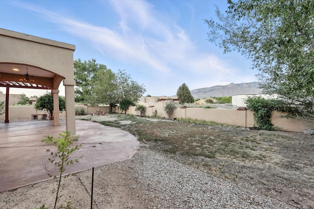 736 Gray Hawk Dr NE, Rio Rancho, NM 87144 - fenced backyard featuring a patio, a mountain view, and a ceiling fan