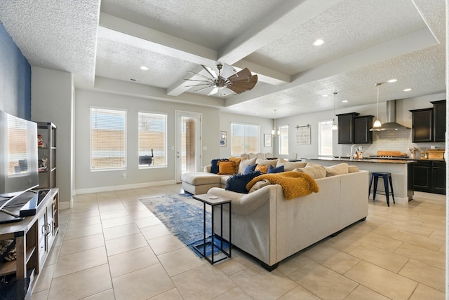 4529 Skyline Loop NE, Rio Rancho, NM 87144 - living room with a textured ceiling, ceiling fan, plenty of natural light, light tile patterned floors, and beamed ceiling