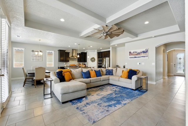 4529 Skyline Loop NE, Rio Rancho, NM 87144 - living room featuring arched walkways, a textured ceiling, light tile patterned floors, plenty of natural light, and beamed ceiling