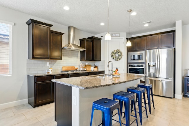 4529 Skyline Loop NE, Rio Rancho, NM 87144 - kitchen with stainless steel appliances, wall chimney exhaust hood, stone counters, tasteful backsplash, and a textured ceiling