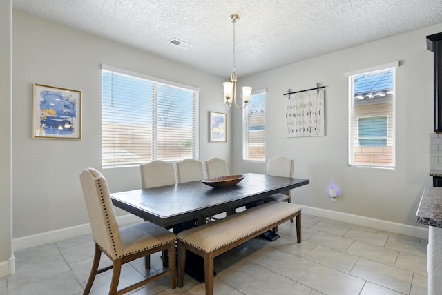4529 Skyline Loop NE, Rio Rancho, NM 87144 - dining area featuring healthy amount of natural light, a textured ceiling, a chandelier, and light tile patterned flooring