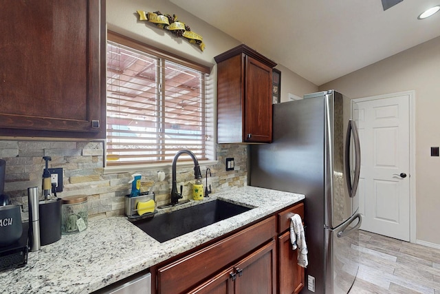 9616 Eucariz Ave SW, Albuquerque, NM 87121 - kitchen featuring backsplash, light wood finished floors, freestanding refrigerator, light stone counters, and vaulted ceiling