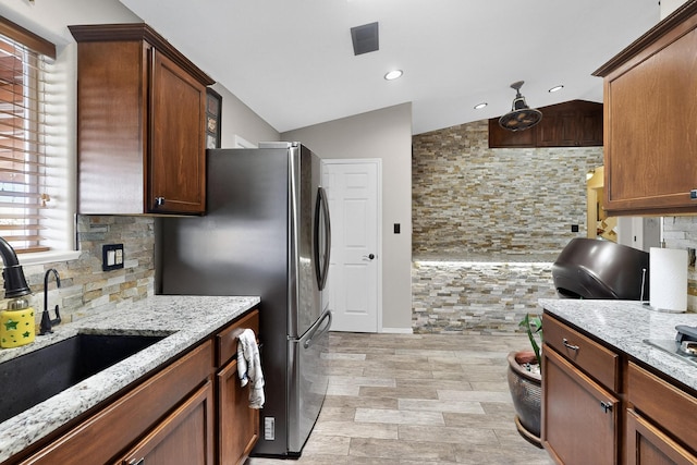 9616 Eucariz Ave SW, Albuquerque, NM 87121 - kitchen with tasteful backsplash, light stone countertops, vaulted ceiling, freestanding refrigerator, and recessed lighting