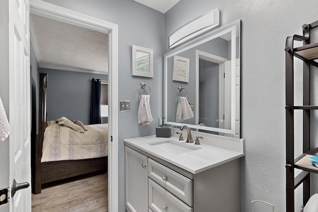 9616 Eucariz Ave SW, Albuquerque, NM 87121 - bathroom featuring ensuite bath, vanity, wood finished floors, and a textured ceiling